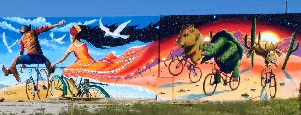 Cowboy on bike mural with Latina and desert animals
