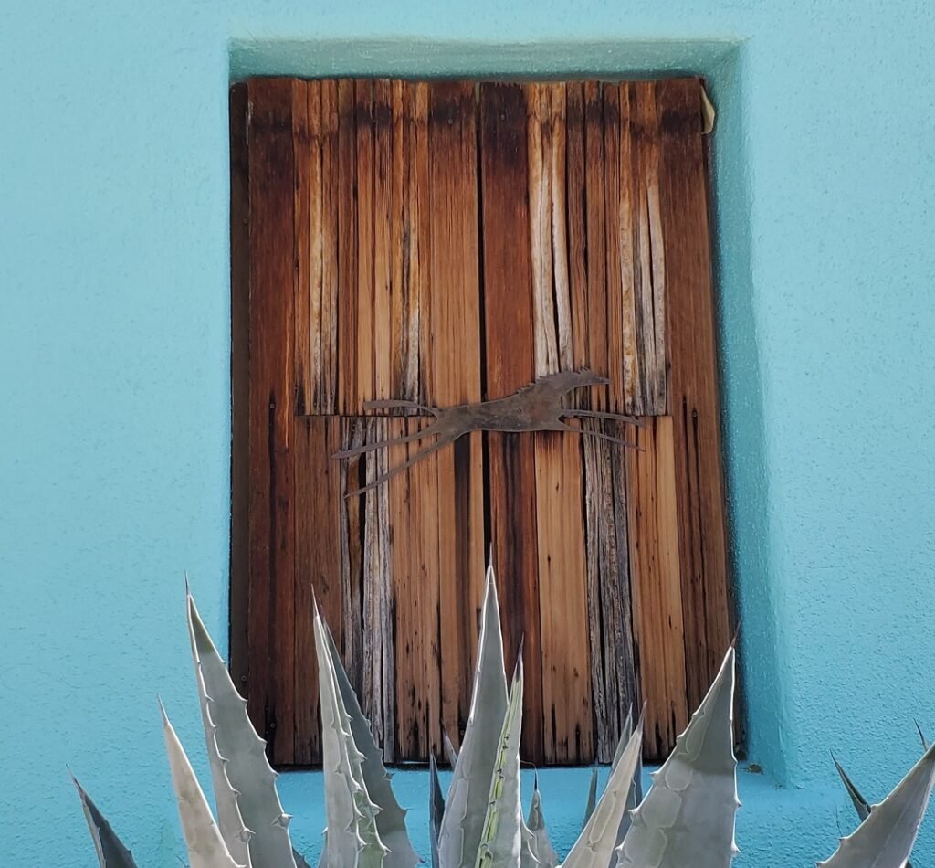 Ocotillo shutters on window with metal horse fastener