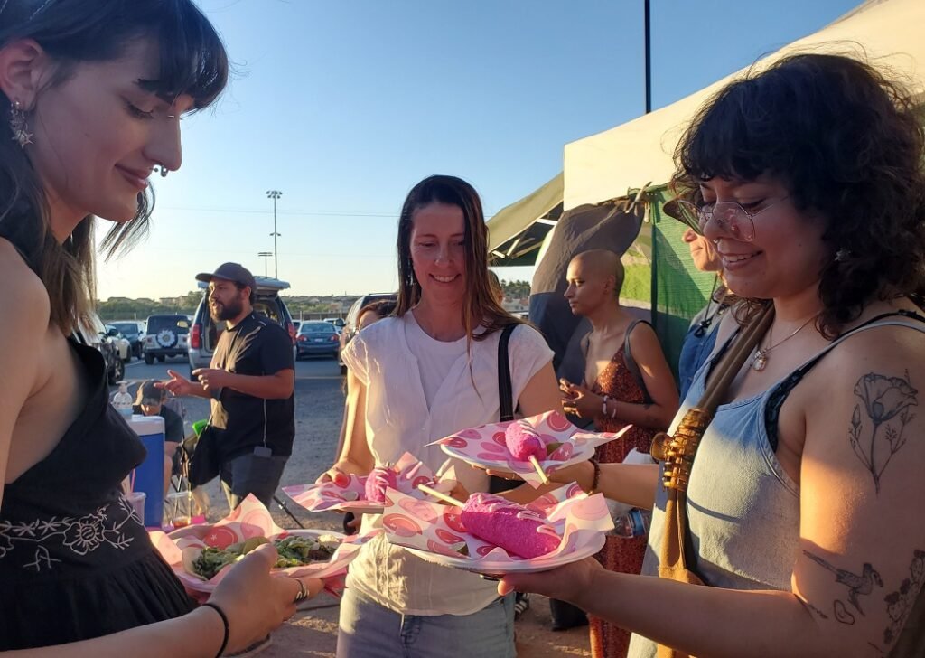 women eating pink elote Tucson Vegan Night Market