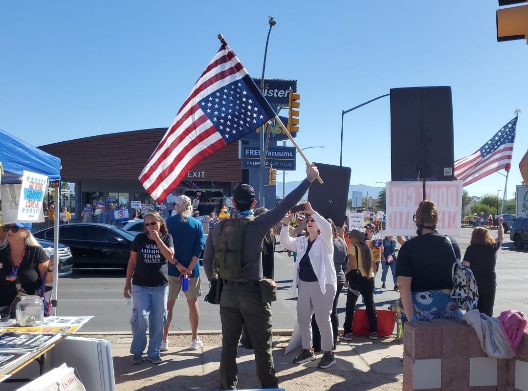 Man weaving U.S. flag in distress position at Speedway and Country Club, Tucson Oct 2025