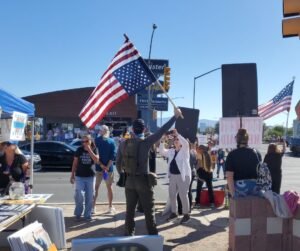 Man weaving U.S. flag in distress position at Speedway and Country Club, Tucson Oct 2025