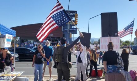 Man weaving U.S. flag in distress position at Speedway and Country Club, Tucson Oct 2025