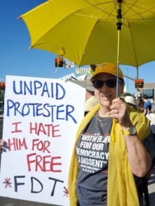 No Kings marcher with unpaid protester sign